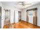 Bedroom with hardwood floors, a ceiling fan, a window with curtains, and a closet with an open door at 109 S Nimbus Ave, Clearwater, FL 33765