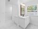 Bright bathroom featuring a white vanity with framed mirror and marble floors at 11709 N Armenia Ave, Tampa, FL 33612