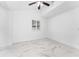 Bright bedroom with marble tile floors, ceiling fan, and window at 11709 N Armenia Ave, Tampa, FL 33612