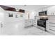 Modern kitchen with white cabinetry, stainless steel appliances, and stylish lighting at 11709 N Armenia Ave, Tampa, FL 33612