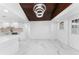 Open living room with a wood plank ceiling, marble floors, and modern light fixture at 11709 N Armenia Ave, Tampa, FL 33612