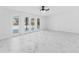 Bright open living room with marble floors, French doors, and a decorative ceiling fan at 11709 N Armenia Ave, Tampa, FL 33612