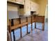 Tiled kitchen area ready for renovation, featuring upper cabinets and exposed plumbing at 1234 11Th Se Cir, Largo, FL 33771