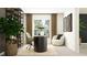 Bright home office featuring a round desk, comfortable chair, shelving, and a large window at 13167 Violet Flame Ave, Wimauma, FL 33598