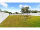 Spacious backyard featuring a swing set and a white vinyl fence for privacy and security at 13380 Great Plains Dr, Riverview, FL 33579