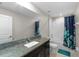 Modern bathroom featuring granite countertops, a large mirror, and a shower-tub combination with stylish blue curtain at 13380 Great Plains Dr, Riverview, FL 33579