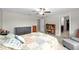 Well-lit bedroom with a ceiling fan, a quilt bed, and a view into the bathroom at 13380 Great Plains Dr, Riverview, FL 33579