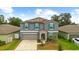 Charming two-story home with grey siding, teal shutters, manicured landscaping, and a two-car garage at 13380 Great Plains Dr, Riverview, FL 33579