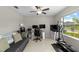 A functional office space featuring a sofa, monitors, a ceiling fan and exercise machine at 13380 Great Plains Dr, Riverview, FL 33579