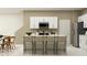 Well-lit modern kitchen featuring white cabinets, an island with seating, and stainless steel appliances at 13515 White Gold Run, Parrish, FL 34219