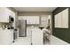 A modern kitchen with white cabinets, stainless steel appliances, and a spacious island with barstool seating at 13515 White Gold Run, Parrish, FL 34219
