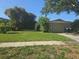 Charming single-story home with lush landscaping, mature palms and driveway with a two-car garage at 1466 Byram Dr, Clearwater, FL 33755
