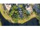 Aerial view of a lakefront home featuring a pool, mature trees, and a well-manicured lawn at 15704 Mifflin Ct, Tampa, FL 33647