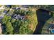 A tranquil home setting by a lake, featuring verdant trees, a private pool, and serene landscaping at 15704 Mifflin Ct, Tampa, FL 33647