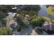 Aerial view of the property showcasing its landscaped yard, mature trees, and neighborhood setting at 15704 Mifflin Ct, Tampa, FL 33647