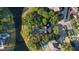 An aerial view of a home showcasing a private pool and lush landscaping bordering a serene lake at 15704 Mifflin Ct, Tampa, FL 33647
