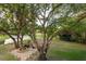 Expansive backyard featuring mature trees, a tranquil pond, and a cozy patio seating area at 15704 Mifflin Ct, Tampa, FL 33647