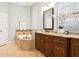 Elegant bathroom featuring a large soaking tub, vanity with granite countertop, and decorative tiling at 15704 Mifflin Ct, Tampa, FL 33647