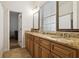 Bathroom with double sink, granite countertop, framed mirrors and tile flooring at 15704 Mifflin Ct, Tampa, FL 33647
