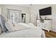 Cozy bedroom features an entertainment center, french doors and a comfortable white quilted comforter at 15704 Mifflin Ct, Tampa, FL 33647