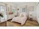 Bright bedroom featuring wood floors, large windows with blinds, and a pink bedspread at 15704 Mifflin Ct, Tampa, FL 33647