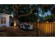 Outdoor deck with dining table and chairs surrounded by ambient lighting and mature trees at 15704 Mifflin Ct, Tampa, FL 33647
