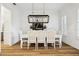 Bright dining room with hardwood floors, a modern chandelier, and seating for six at 15704 Mifflin Ct, Tampa, FL 33647