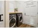 Well-lit laundry room with modern washer and dryer, wood counter, and a white door at 15704 Mifflin Ct, Tampa, FL 33647