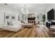 Sun-filled living room featuring a cozy fireplace, modern lighting, and stylish seating arrangement on wood floors at 15704 Mifflin Ct, Tampa, FL 33647