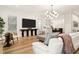 An open-concept living space with wood flooring, modern lighting, and a view into the adjacent kitchen area at 15704 Mifflin Ct, Tampa, FL 33647