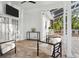 Covered patio with brick floors, white posts, and outdoor furniture arrangement at 15704 Mifflin Ct, Tampa, FL 33647