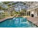 Pool with screened enclosure, brick patio, and view of the well maintained backyard at 15704 Mifflin Ct, Tampa, FL 33647