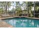 Pool with screened enclosure, brick surround, fountain, and view of backyard greenery at 15704 Mifflin Ct, Tampa, FL 33647
