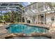 Large pool featuring screened enclosure, brick paving, jacuzzi, and the two story white house at 15704 Mifflin Ct, Tampa, FL 33647