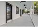 Spacious covered porch with painted wood flooring, black door and trim, and ceiling fans at 15704 Mifflin Ct, Tampa, FL 33647