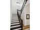 A modern staircase featuring a black railing and white risers, adding a touch of elegance to the home's interior at 15704 Mifflin Ct, Tampa, FL 33647