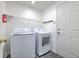 Bright laundry room includes a new washer, dryer, and ample shelving for storage and organization at 1639 Wakefield Dr, Brandon, FL 33511