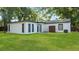 Expansive backyard with a well-maintained lawn, white-painted exterior, and dark trim at 1715 N Alexander Rd, Tampa, FL 33603