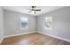 Well-lit bedroom with neutral walls, wood-look floors, ceiling fan, and windows providing natural light at 1715 N Alexander Rd, Tampa, FL 33603