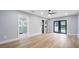 Spacious bedroom with hardwood floors, leading to a bathroom with glass enclosed shower at 1715 N Alexander Rd, Tampa, FL 33603