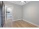 Bright bedroom featuring wood floors, neutral paint, and ensuite bathroom with modern finishes at 1715 N Alexander Rd, Tampa, FL 33603