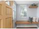 Inviting entryway featuring a built-in bench, floating shelf, and a view to the green outdoors at 1715 N Alexander Rd, Tampa, FL 33603