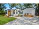 Charming home with a bright yellow front door, clean white exterior, and a modern driveway at 1715 N Alexander Rd, Tampa, FL 33603