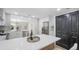 Charming kitchen featuring stainless steel appliances, black accent doors, and quartz countertop at 1715 N Alexander Rd, Tampa, FL 33603