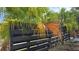 Black wood fence surrounded by lush, tropical foliage at 1755 Sunset Point Rd, Clearwater, FL 33755
