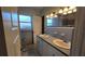 Bathroom with dual vanities, granite counters, tiled walls, and tiled mirrors at 1755 Sunset Point Rd, Clearwater, FL 33755