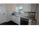 White kitchen with stylish cabinetry and granite counters, with a window over the sink at 1755 Sunset Point Rd, Clearwater, FL 33755