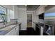 Galley kitchen with white cabinetry, stainless steel appliances, and tiled backsplash at 1755 Sunset Point Rd, Clearwater, FL 33755