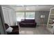 Cozy sunroom with a plush sofa, accent chair, and plenty of natural light at 1755 Sunset Point Rd, Clearwater, FL 33755
