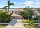 Aerial shot featuring the home, manicured lawn, landscaping, driveway, and partial lake view at 1858 Mira Lago Cir, Ruskin, FL 33570